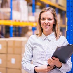 Warehouse team member smiling while holding clipboard